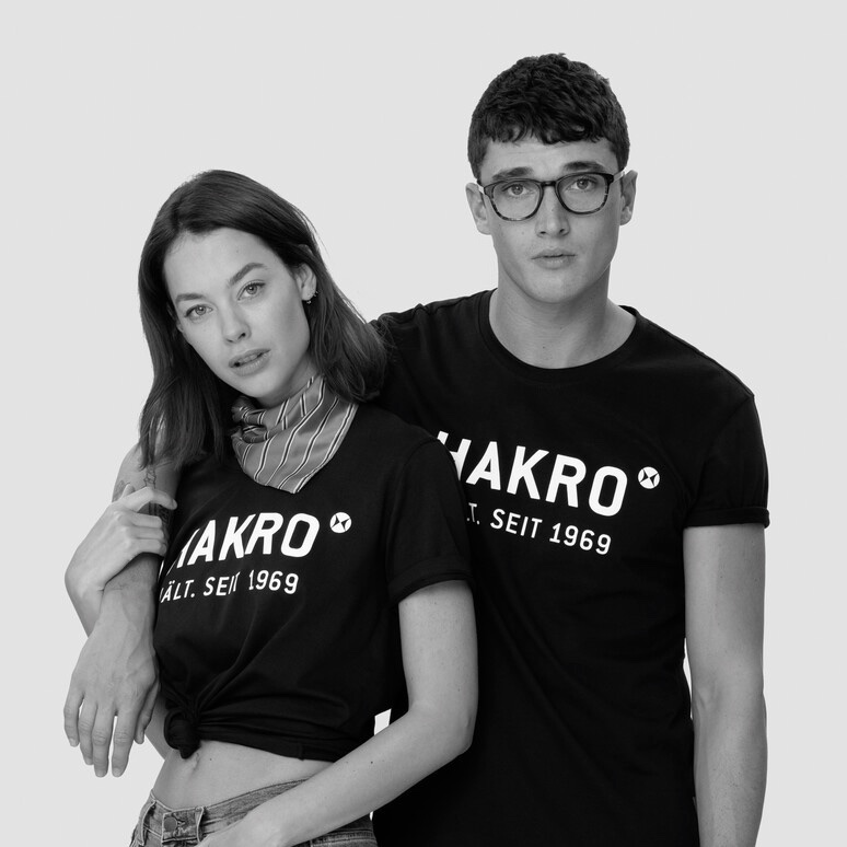 Zwei Menschen mit HAKRO-T-Shirts (Bildnachweis: https://corpotex.de/produkt/hakro-t-shirt-logo/)